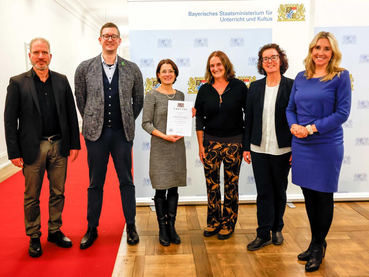 Von links nach rechts:
Dr. Jens Müller (Mitarbeiter MB-Ost) – Benjamin Wipfler (Profilkoordinator FOSBOS Neuburg) – Dr. Eva Hertle (Schulleiterin BSZ Neuburg) – Christine Voglgsang (Regens-Wagner-Berufsschule Schrobenhausen) – Martina Wenzel (FOSBOS Neuburg, Weitere Ständige Vertreterin der Schulleiterin) – Anna Stolz (Bayerische Staatsministerin für Unterricht und Kultus)